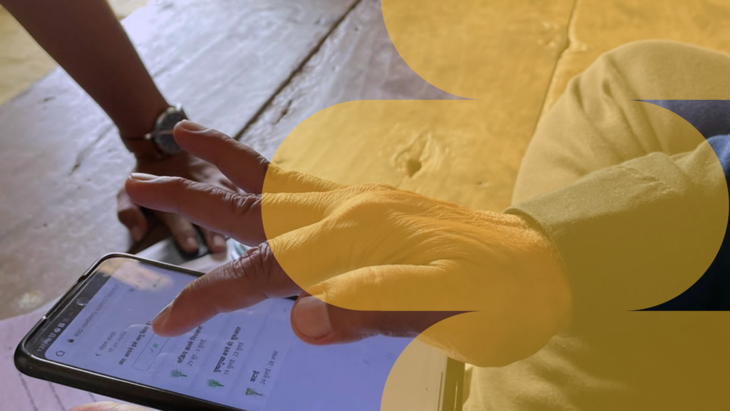 Image of a farmer using the FarmRise app, powered by Bayer, on a mobile device. The farmer is seen actively engaging with the app's interface, utilizing agricultural tools and accessing information specific to rice paddy practices for optimized farming.