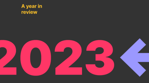 Graphic for Useberry's 'A Year in Review' blog post with '2023' in large red numbers centered on a dark background, with a backward-pointing blue arrow on the right, signifying reflection on the past year